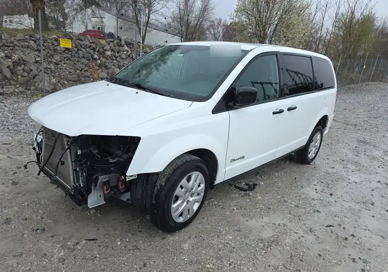 White 2019 Dodge Grand Caravan with front-end damage at an auction yard in Prairie Grove, Arkansas
