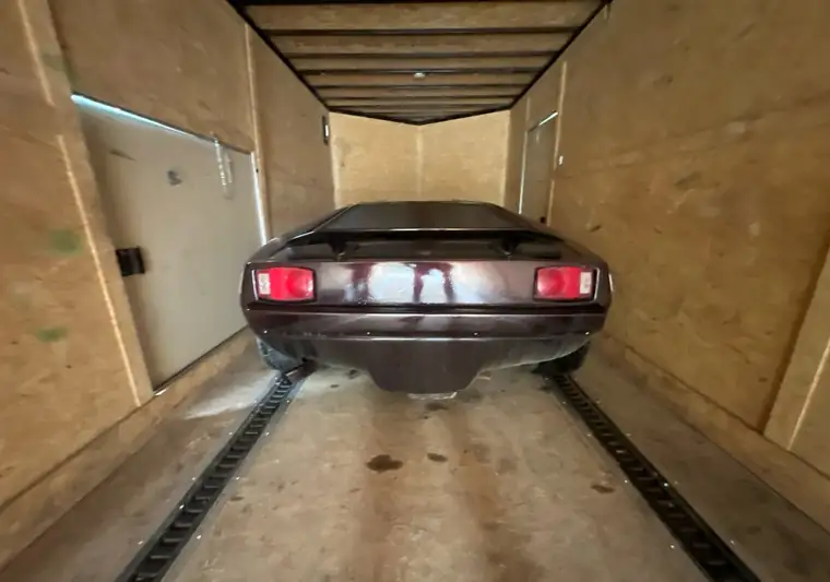 Rear view of the same Cimbria SS inside the enclosed trailer, on a track-style floor with space on both sides