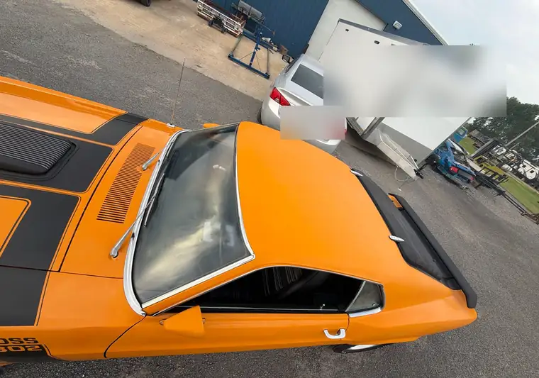 Orange 1970 Ford Mustang Fastback beside a white enclosed trailer at pickup in Blytheville, Arkansas