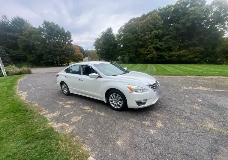 White 2015 Nissan Altima on a driveway at pickup in Cheshire, Connecticut