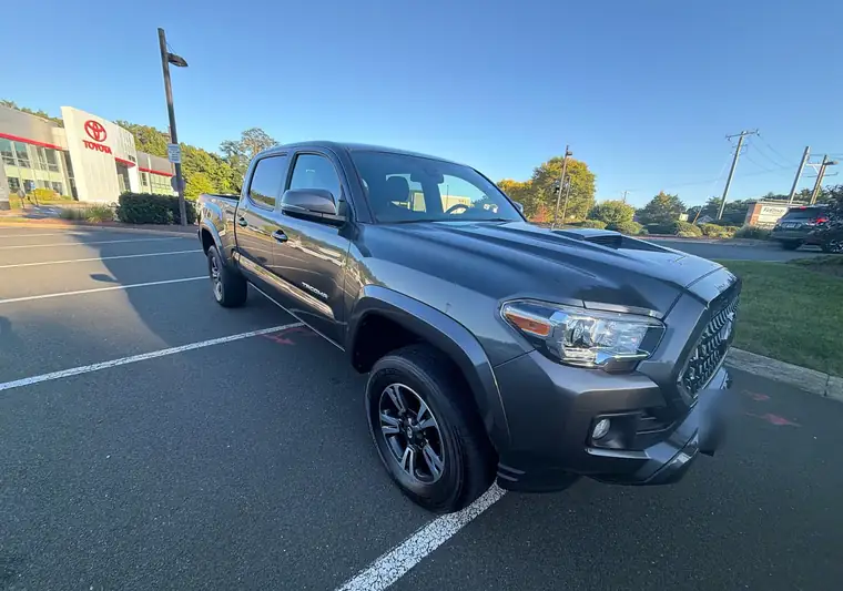 Gray 2019 Toyota Tacoma crew cab at pickup in West Simsbury, Connecticut, with a Toyota dealership in the background