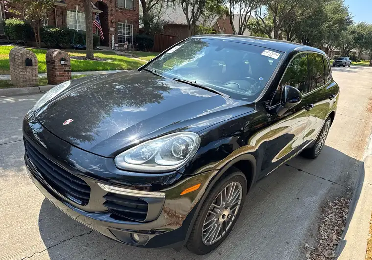 The same Porsche Cayenne on a residential street at delivery in Frisco, Texas