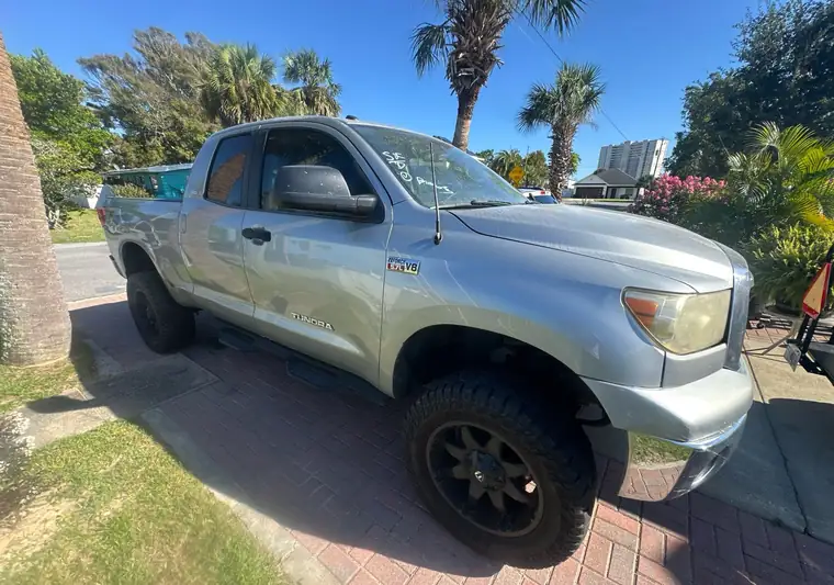 The same Toyota Tundra on a driveway lined with palm trees at delivery in Panama City Beach, Florida