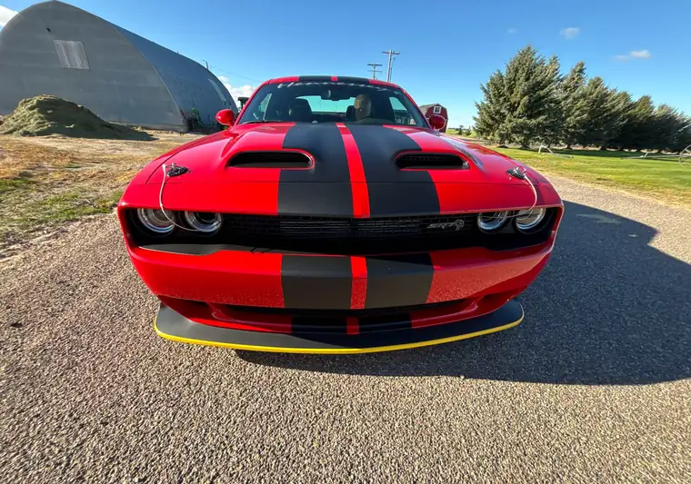Red 2022 Dodge Challenger with black stripes on a gravel road in American Falls, Idaho
