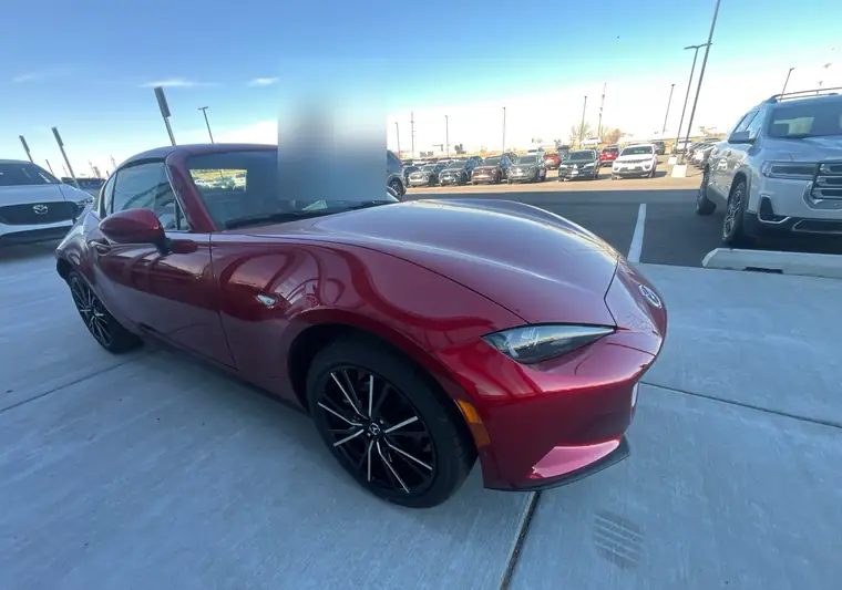 Red 2025 Mazda MX-5 Miata RF hardtop convertible outside a dealership in Idaho Falls, Idaho
