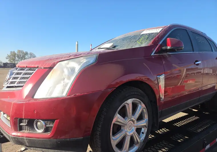Red 2016 Cadillac SRX with front-end damage on a car hauler at an IAA yard in Indianapolis