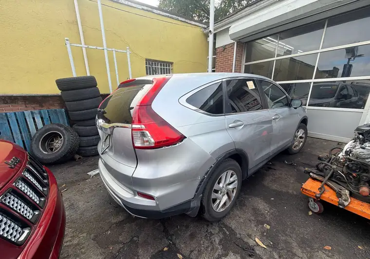 The same CR-V in a yard beside stacked tires at delivery in Newark, New Jersey