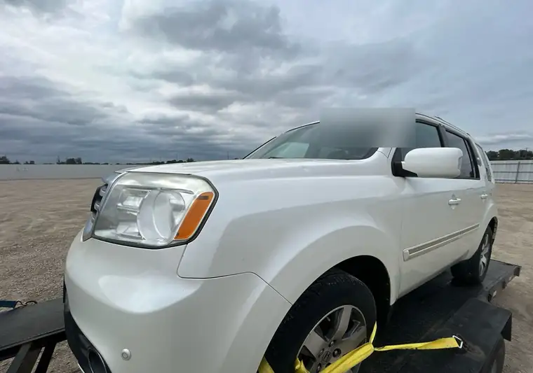 White 2014 Honda Pilot on a car carrier at the Copart yard in Cedar Rapids, Iowa