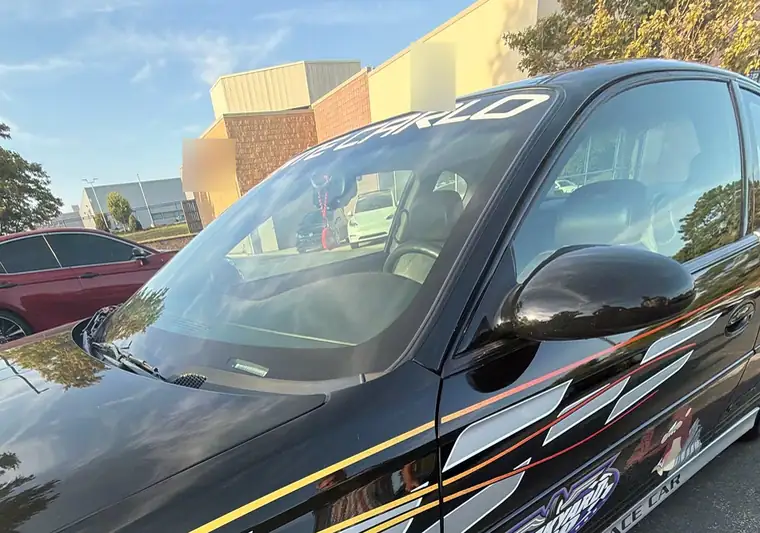 Black 2001 Chevrolet Monte Carlo with yellow and silver graphics in a parking lot in Mission, Kansas