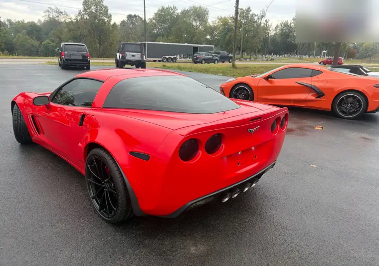 Red 2012 Chevrolet Corvette with black wheels in a parking lot in Jamestown, Kentucky