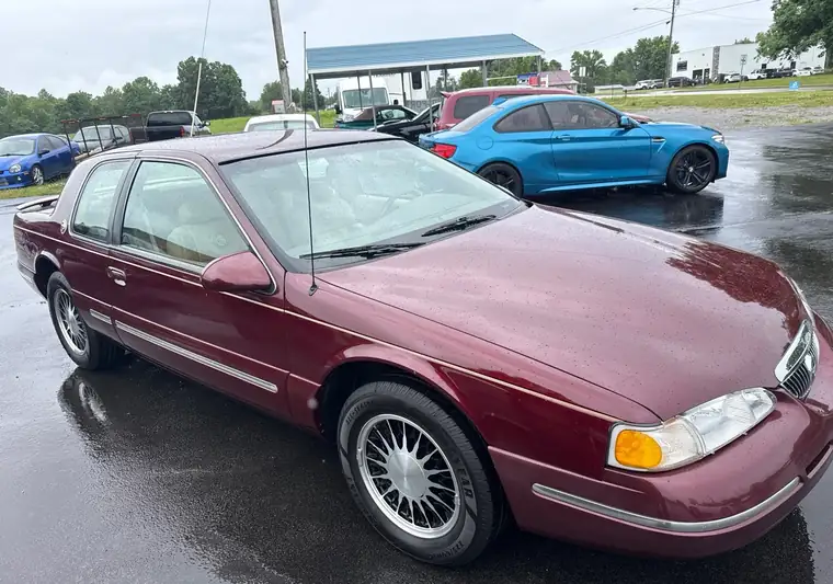 Burgundy 1997 Mercury Cougar on a wet parking lot in Jamestown, Kentucky