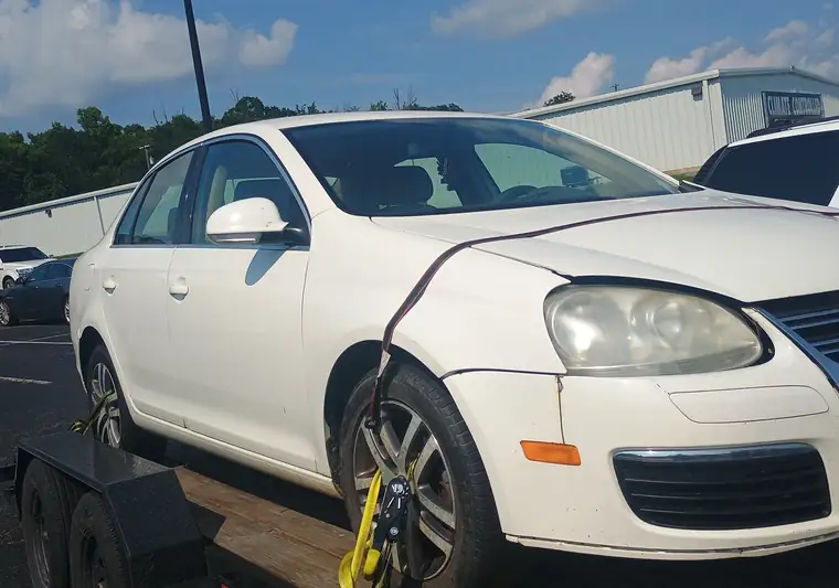 White Volkswagen Jetta strapped on a tow trailer at pickup in Danville, Kentucky