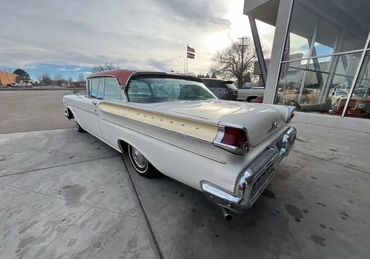 White and red 1957 Mercury Montclair outside a classic-car dealership at pickup in Greeley, Colorado