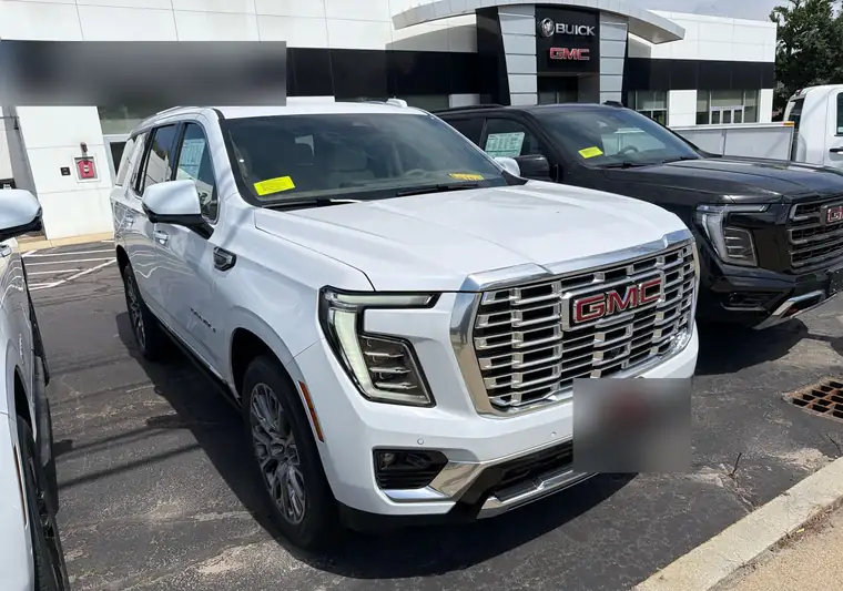White 2026 GMC Yukon Denali in a dealership lot in Franklin, Massachusetts