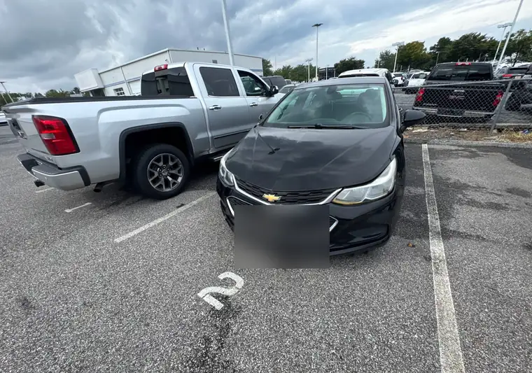 Black 2017 Chevrolet Cruze with side damage in a parking lot in Clarksville, Maryland