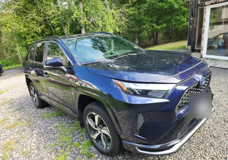 Dark blue 2023 Toyota RAV4 Prime on a gravel lot in York, Maine
