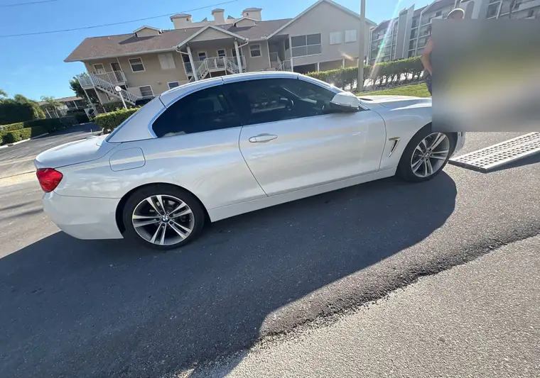 The same BMW 4 Series convertible on a street beside loading ramps at delivery in Marco Island, Florida