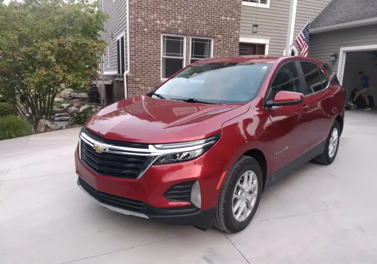 Red 2023 Chevrolet Equinox on a driveway in Northville, Michigan