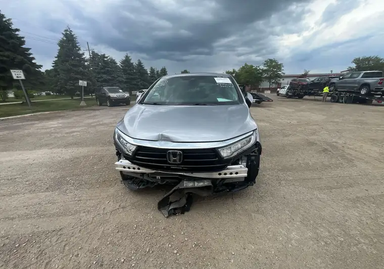 Silver 2024 Honda Odyssey Touring with a crushed front end at the IAA yard in Belleville, Michigan
