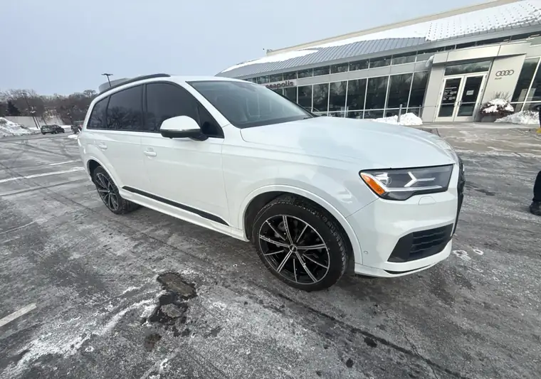 White 2020 Audi Q7 at a dealership lot in Golden Valley, Minnesota in winter