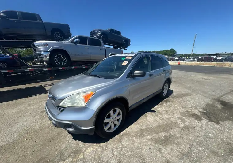 Silver 2007 Honda CR-V at the Manheim auction yard in Kenly, North Carolina, with a car hauler behind it