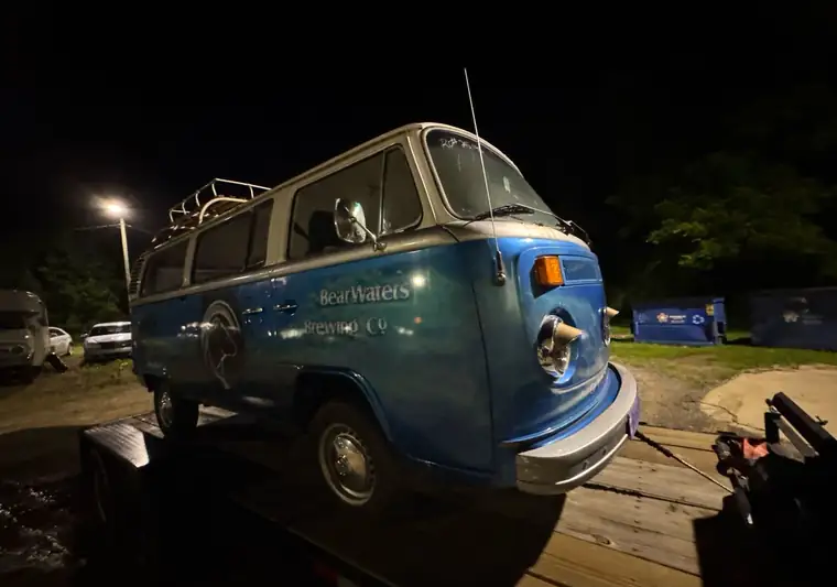 Blue and white 1977 Volkswagen Type 2 bus at night on a tilt trailer at pickup in Waynesville, North Carolina