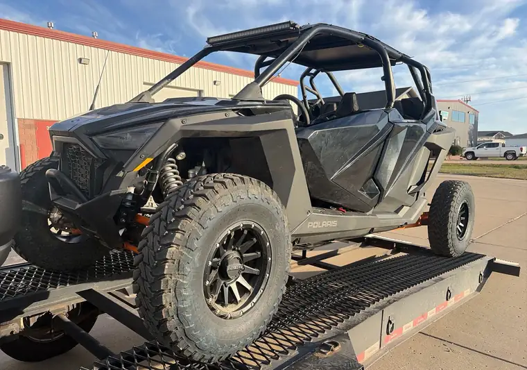 Black Polaris Pro XP side-by-side loaded on a tilt trailer at pickup in Mandan, North Dakota