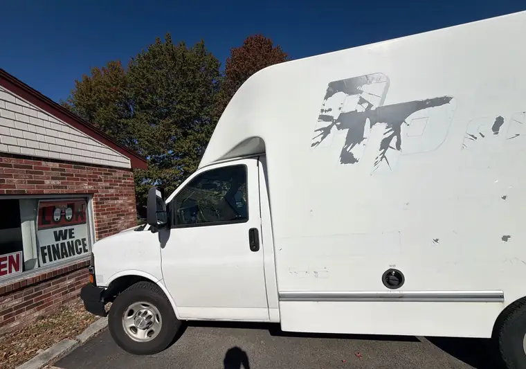 The same box van outside a used-car dealer at delivery in Rowley, Massachusetts