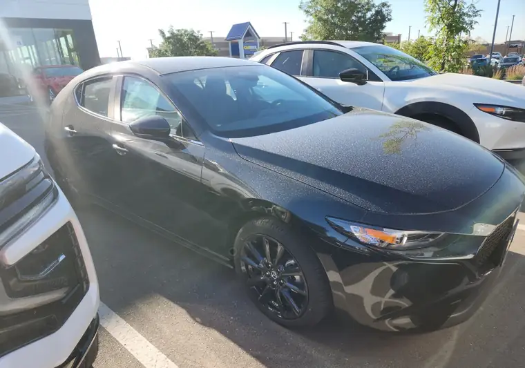 The same Mazda3 at delivery in a dealer lot in Loveland, Colorado