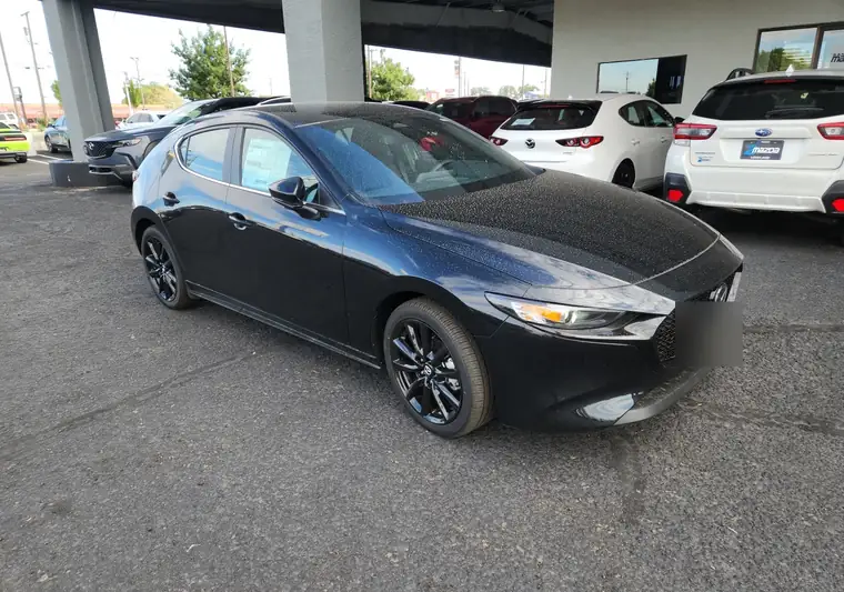 Black 2026 Mazda3 hatchback at pickup at a dealer in Santa Fe, New Mexico (plate blurred)
