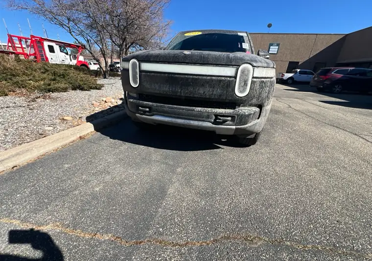 The same Rivian R1T, dusty from the road, at delivery in Boulder, Colorado