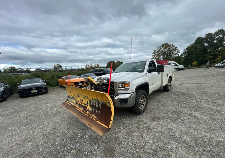 White 2017 GMC Sierra 3500 HD service truck with a yellow snow plow at pickup in Brewster, New York