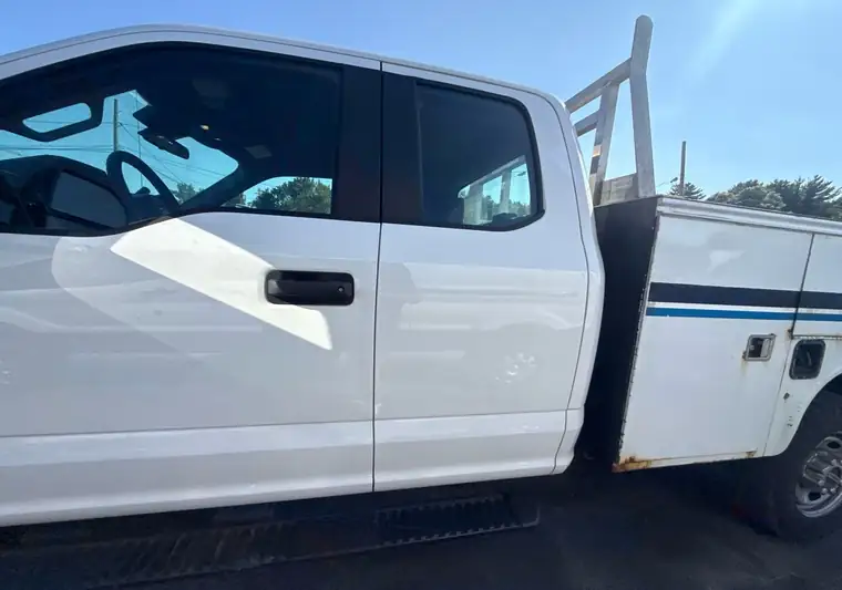 The same F-250 utility truck on a lot at delivery at a dealer in Rowley, Massachusetts