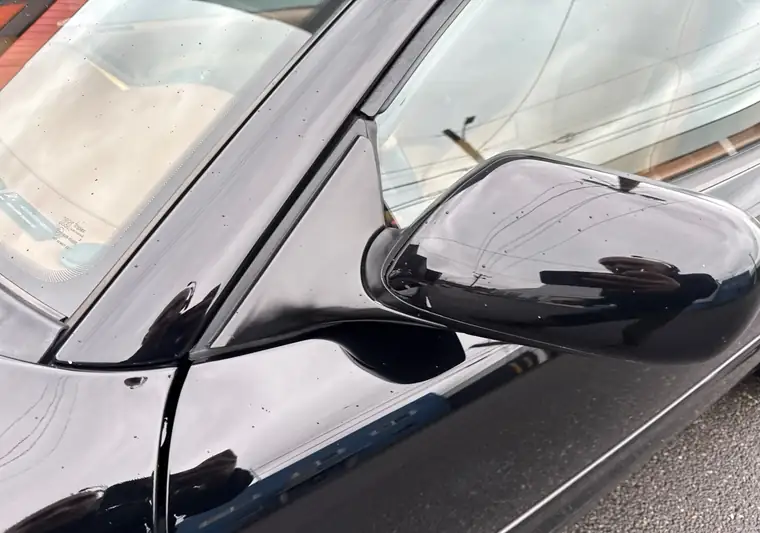 Black 2002 Aston Martin DB7 convertible, side mirror detail, at pickup at a dealer in Portland, Oregon