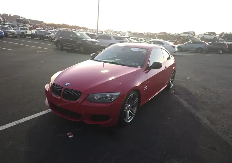 Red 2012 BMW 335is coupe, front three-quarter view, in an auction lot at pickup in Manheim, Pennsylvania
