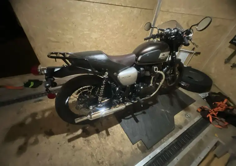 Kawasaki W800 Cafe motorcycle strapped down inside an enclosed trailer at pickup near Johnstown, Pennsylvania