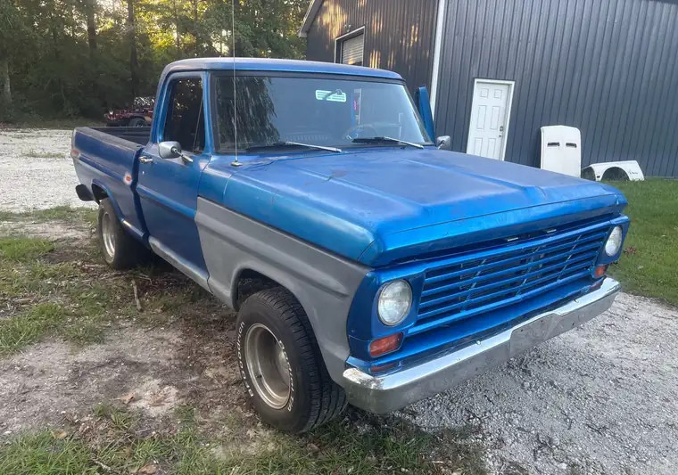 Blue and gray 1968 Ford F-100 short-bed pickup on a gravel drive at pickup in Moncks Corner, South Carolina