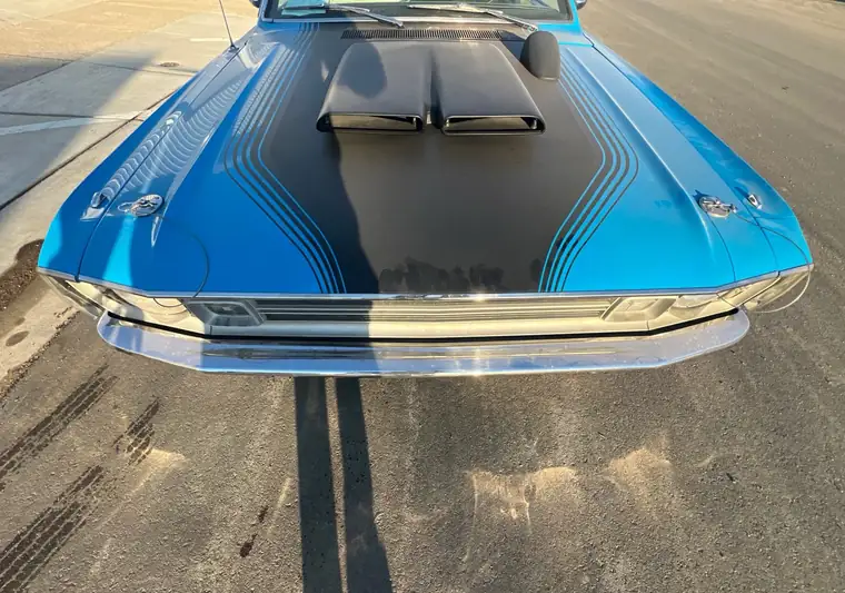 Blue 1972 Dodge Demon with a black hood scoop on the street at pickup in White, South Dakota