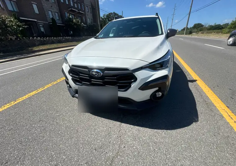 White 2025 Subaru Crosstrek on a street at pickup in Nashville, Tennessee, plate blurred